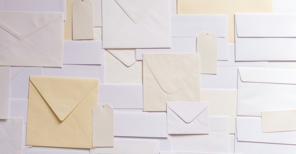 Stapel witte en cr&egrave;mekleurige enveloppen