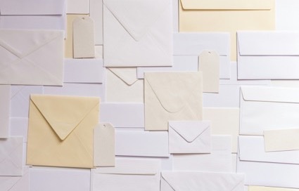 Stapel witte en cr&egrave;mekleurige enveloppen