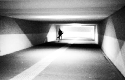 Persoon loopt door een verlichte voetgangerstunnel
